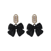 Black acrylic bowknot earrings featuring sparkling cubic zirconia crystals in a stylish drop design.